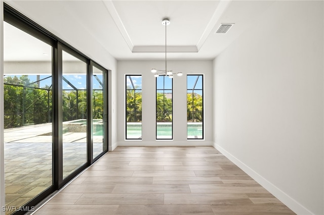 2110 SW 52nd Ter, Cape Coral, FL 33914 - unfurnished dining area with healthy amount of natural light, a tray ceiling, a chandelier, and baseboards
