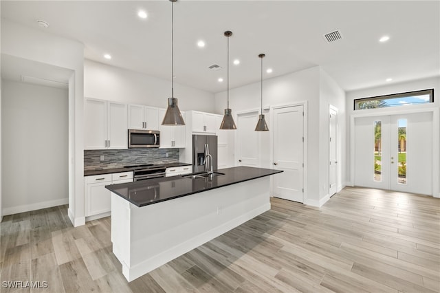 2110 SW 52nd Ter, Cape Coral, FL 33914 - kitchen with stainless steel appliances, a sink, dark countertops, white cabinets, and backsplash