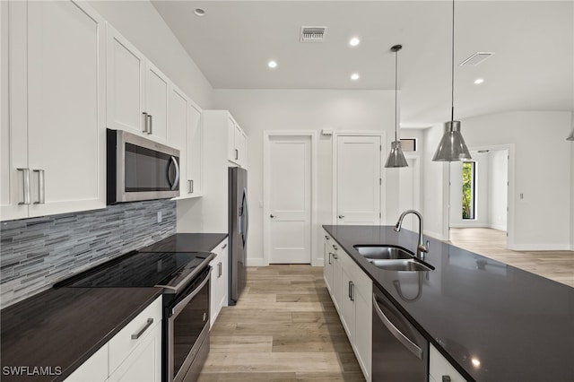 2110 SW 52nd Ter, Cape Coral, FL 33914 - kitchen featuring stainless steel appliances, dark countertops, a sink, light wood-style flooring, and recessed lighting
