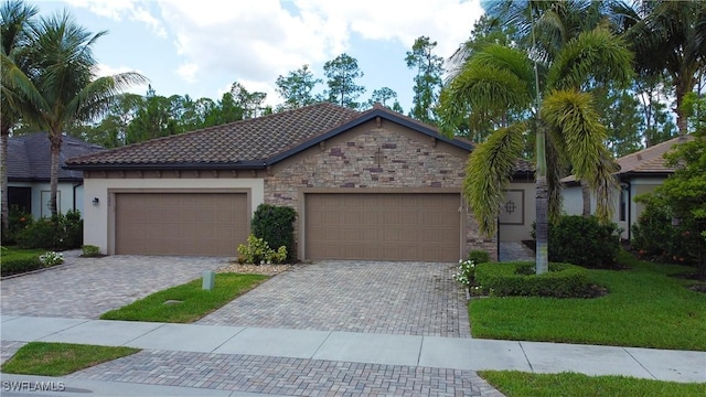 9076 Glenforest Dr, Naples, FL 34120 - view of front facade featuring an attached garage, stone siding, decorative driveway, stucco siding, and a tile roof