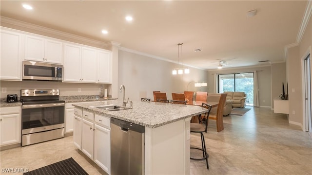9076 Glenforest Dr, Naples, FL 34120 - kitchen featuring stainless steel appliances, a sink, crown molding, ceiling fan, and a center island with sink