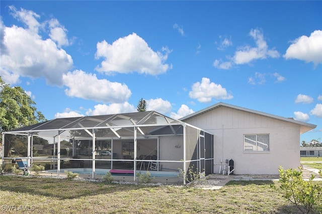19006 Flamingo Rd, Fort Myers, FL 33967 - back of property featuring an outdoor pool, a lawn, glass enclosure, and a patio area