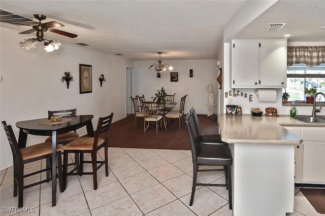 19006 Flamingo Rd, Fort Myers, FL 33967 - dining space with light tile patterned flooring, ceiling fan, a chandelier, a textured ceiling, and light colored carpet