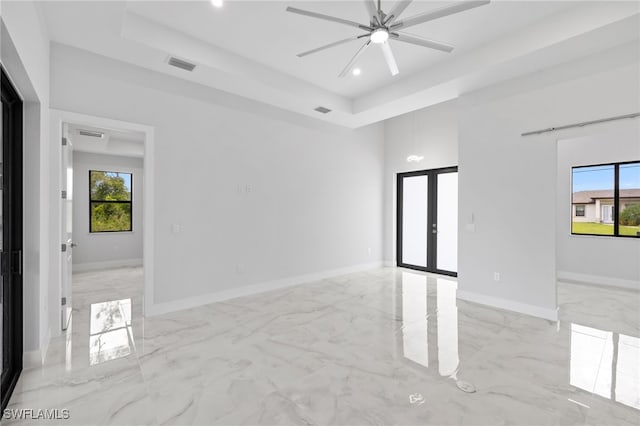 2513 13th St SW, Lehigh Acres, FL 33976 - spare room with french doors, light marble finish floors, a raised ceiling, recessed lighting, and ceiling fan