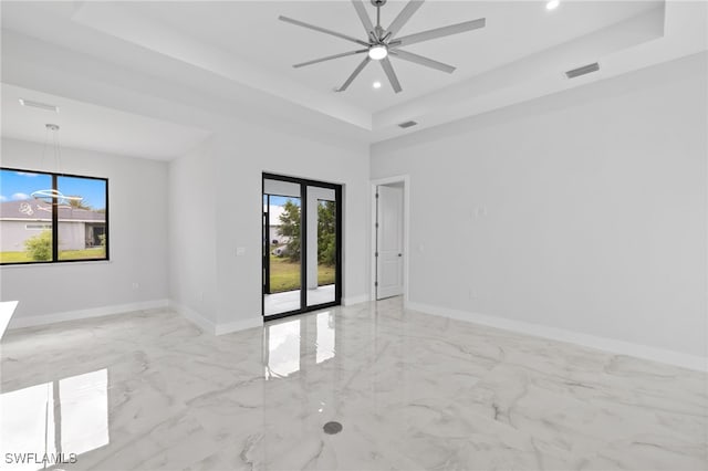 2513 13th St SW, Lehigh Acres, FL 33976 - spare room with a tray ceiling, ceiling fan, light marble finish floors, recessed lighting, and baseboards