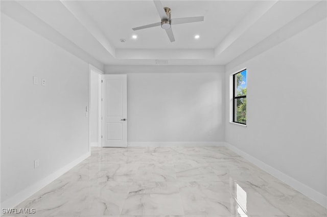 2513 13th St SW, Lehigh Acres, FL 33976 - empty room featuring a tray ceiling, baseboards, recessed lighting, a ceiling fan, and marble finish floors
