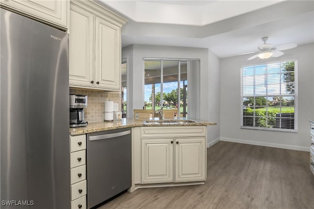23560 Wisteria Pointe Dr Unit 506, Estero, FL 34135 - kitchen with stainless steel appliances, a sink, baseboards, wood finished floors, and healthy amount of natural light