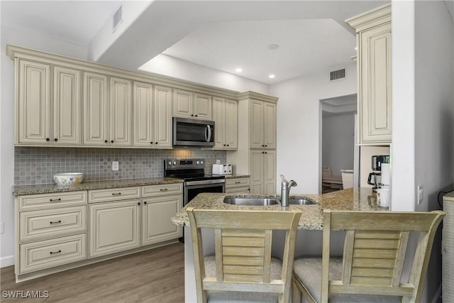 23560 Wisteria Pointe Dr Unit 506, Estero, FL 34135 - kitchen featuring appliances with stainless steel finishes, cream cabinetry, a sink, and recessed lighting