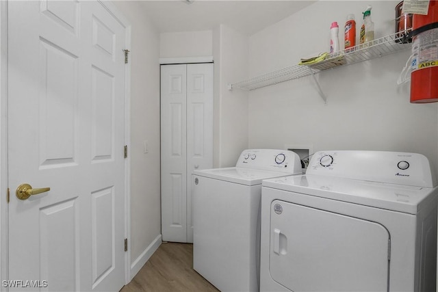 23560 Wisteria Pointe Dr Unit 506, Estero, FL 34135 - laundry room featuring washer and clothes dryer, light wood-type flooring, and baseboards