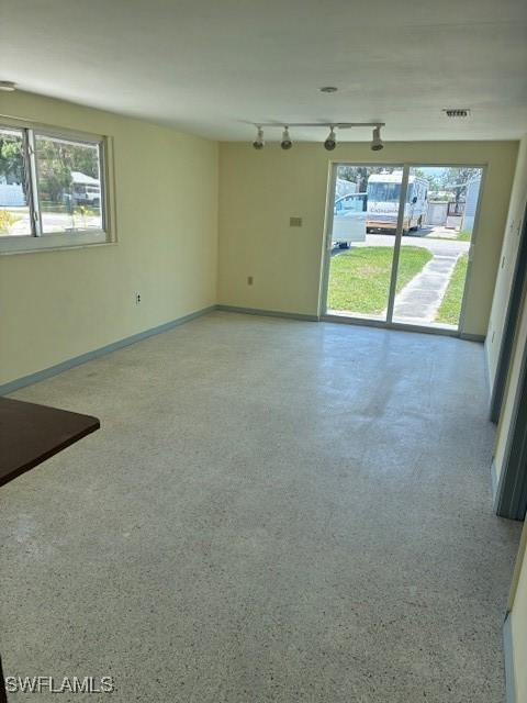 1610 Woodlawn Ave, Punta Gorda, FL 33950 - unfurnished living room featuring rail lighting and baseboards