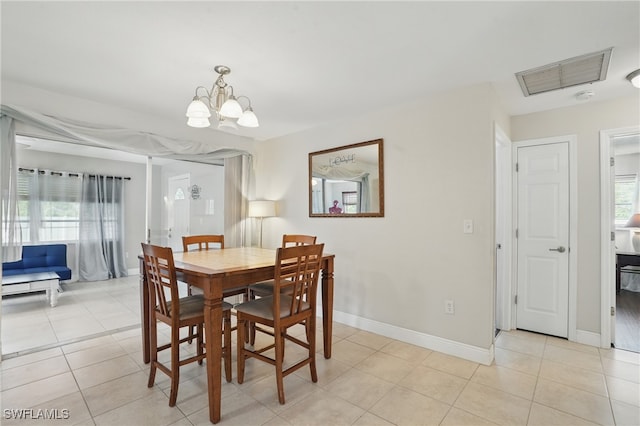 426 Chestnut Ave NW, Port Charlotte, FL 33952 - dining space featuring a chandelier, light tile patterned floors, and baseboards