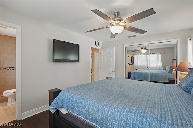 426 Chestnut Ave NW, Port Charlotte, FL 33952 - bedroom with baseboards, ceiling fan, a closet, wood finished floors, and ensuite bathroom