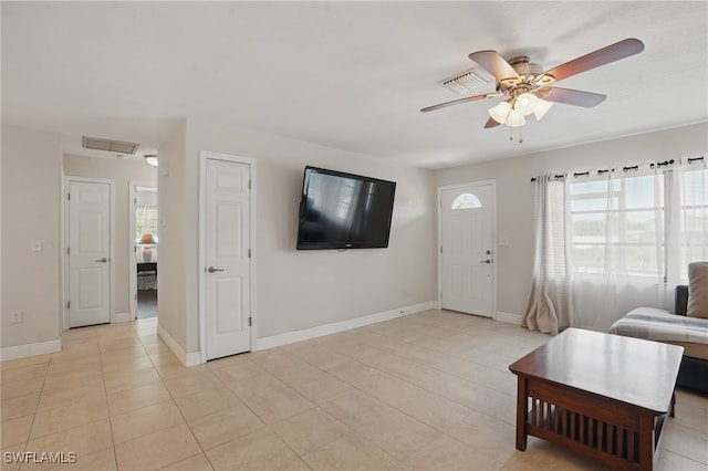 426 Chestnut Ave NW, Port Charlotte, FL 33952 - living room featuring a ceiling fan, light tile patterned flooring, and baseboards