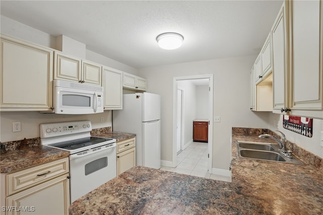 426 Chestnut Ave NW, Port Charlotte, FL 33952 - kitchen featuring white appliances, cream cabinetry, a sink, dark countertops, and light tile patterned floors