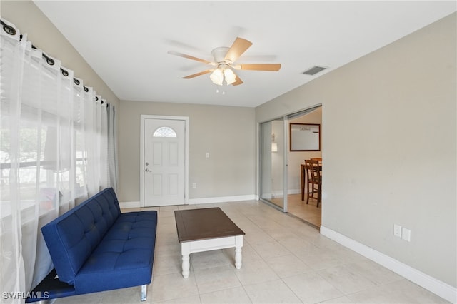 426 Chestnut Ave NW, Port Charlotte, FL 33952 - unfurnished living room featuring ceiling fan, light tile patterned floors, and baseboards