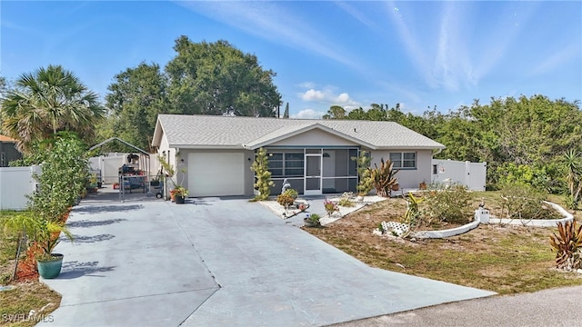 426 Chestnut Ave NW, Port Charlotte, FL 33952 - ranch-style house with a gate, concrete driveway, stucco siding, and a sunroom