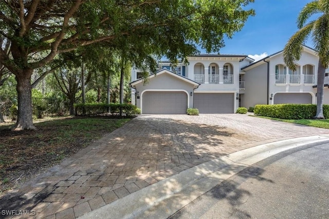21726 Baccarat Ln Unit 201, Estero, FL 33928 - mediterranean / spanish-style house featuring decorative driveway, a balcony, stucco siding, and a garage