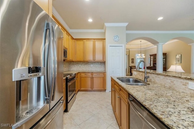 21726 Baccarat Ln Unit 201, Estero, FL 33928 - kitchen featuring stainless steel appliances, decorative columns, a sink, arched walkways, and crown molding