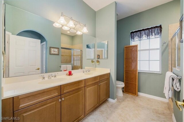 21726 Baccarat Ln Unit 201, Estero, FL 33928 - full bathroom with tiled shower, toilet, double vanity, baseboards, and tile patterned flooring
