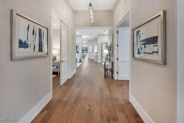 917 Tierra Lago Way, Naples, FL 34119 - hall featuring wood finished floors, baseboards, and a chandelier