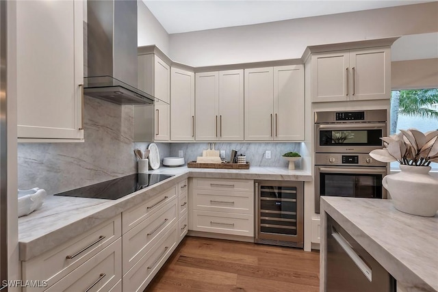 917 Tierra Lago Way, Naples, FL 34119 - kitchen featuring wall chimney exhaust hood, wine cooler, double oven, decorative backsplash, and wood finished floors