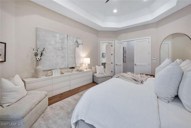 917 Tierra Lago Way, Naples, FL 34119 - bedroom featuring wood finished floors, a tray ceiling, and recessed lighting