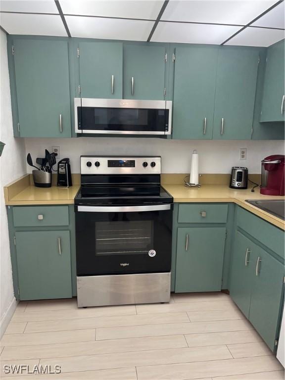 1740 Pine Valley Dr Unit 205, Fort Myers, FL 33907 - kitchen with stainless steel appliances, light countertops, light wood-type flooring, and a drop ceiling