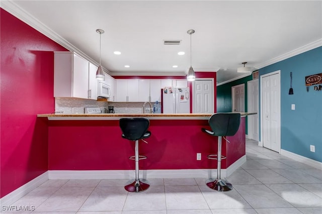 4520 Douglas Ln, Lehigh Acres, FL 33973 - kitchen with white appliances, a peninsula, crown molding, white cabinets, and decorative backsplash