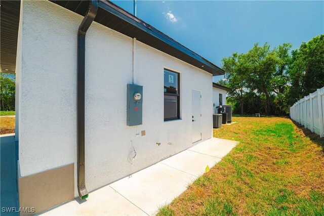3203 18th St W, Lehigh Acres, FL 33971 - view of side of property featuring stucco siding and cooling unit
