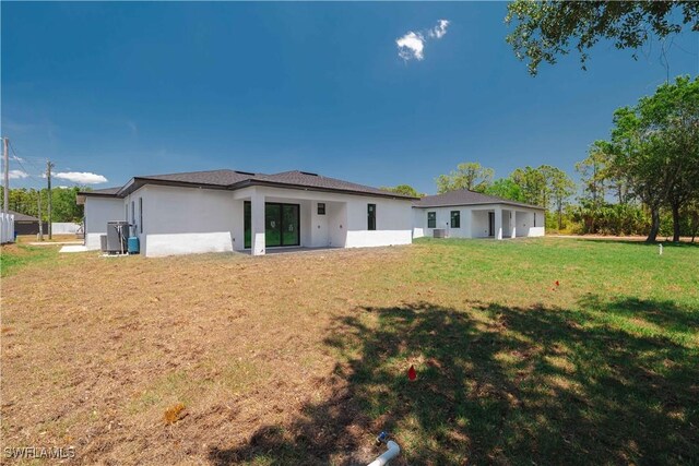 3203 18th St W, Lehigh Acres, FL 33971 - back of property with a yard and stucco siding