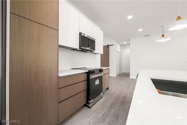 3203 18th St W, Lehigh Acres, FL 33971 - kitchen with black range with electric cooktop, light countertops, white cabinetry, a barn door, and pendant lighting