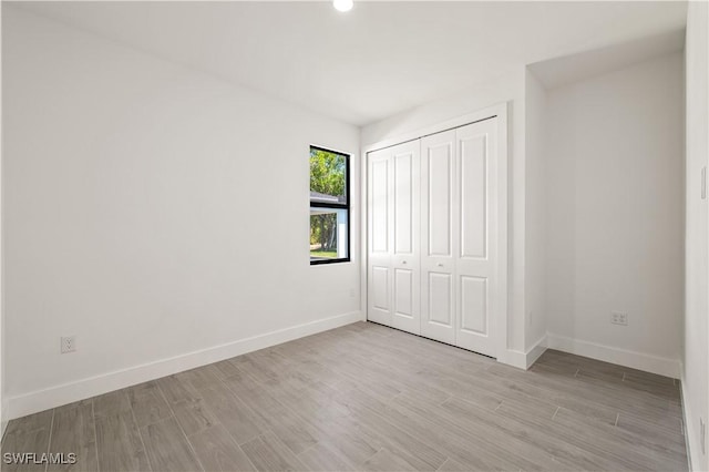 3203 18th St W, Lehigh Acres, FL 33971 - unfurnished bedroom featuring baseboards, light wood finished floors, a closet, and recessed lighting