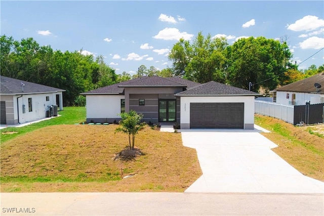 3203 18th St W, Lehigh Acres, FL 33971 - view of front facade featuring stucco siding, driveway, french doors, an attached garage, and a shingled roof
