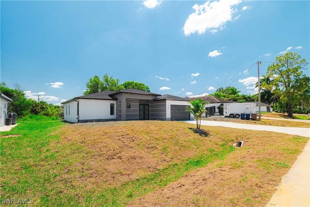 3203 18th St W, Lehigh Acres, FL 33971 - view of front of property with driveway, a garage, a front lawn, cooling unit, and stucco siding