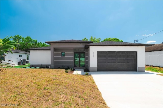 3203 18th St W, Lehigh Acres, FL 33971 - prairie-style home featuring stucco siding, a garage, driveway, and a front lawn