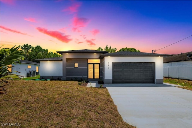 3203 18th St W, Lehigh Acres, FL 33971 - view of front of property with stucco siding, concrete driveway, a garage, and a lawn