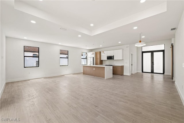 3203 18th St W, Lehigh Acres, FL 33971 - unfurnished living room featuring recessed lighting, french doors, baseboards, a raised ceiling, and light wood finished floors