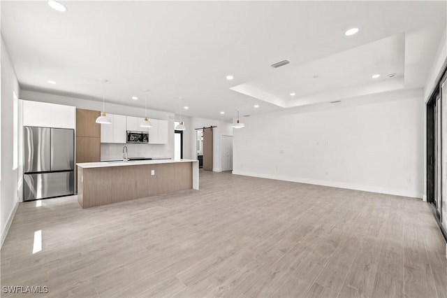3203 18th St W, Lehigh Acres, FL 33971 - kitchen with appliances with stainless steel finishes, a barn door, a kitchen island with sink, recessed lighting, and a sink