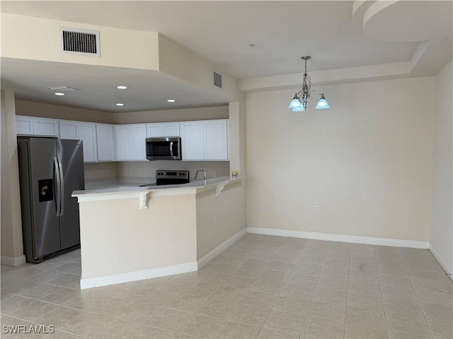 3947 Del Sol Ln Unit 203, Cape Coral, FL 33909 - kitchen with appliances with stainless steel finishes, a peninsula, light tile patterned flooring, light countertops, and white cabinetry
