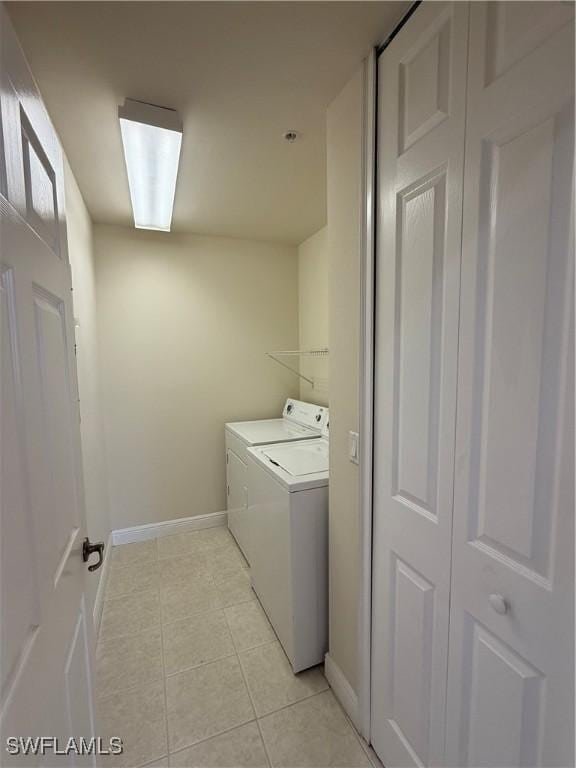 3947 Del Sol Ln Unit 203, Cape Coral, FL 33909 - laundry area featuring washer and dryer, baseboards, and light tile patterned flooring