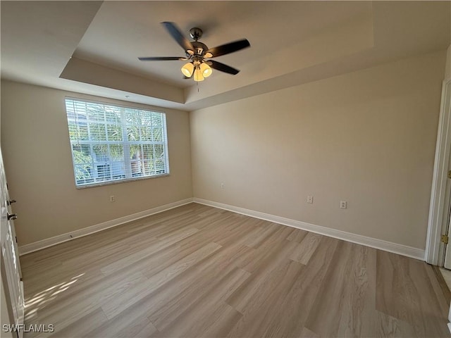 3947 Del Sol Ln Unit 203, Cape Coral, FL 33909 - empty room with a raised ceiling, a ceiling fan, light wood-style floors, and baseboards