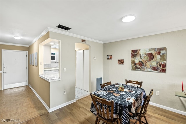 909 SE 46th Ln Unit 104, Cape Coral, FL 33904 - dining room featuring arched walkways, baseboards, ornamental molding, and wood finished floors