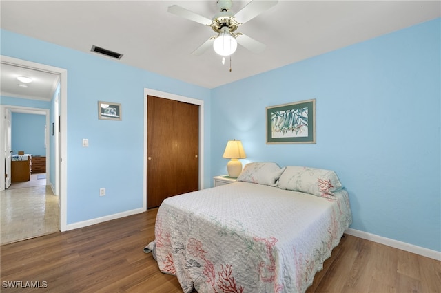 909 SE 46th Ln Unit 104, Cape Coral, FL 33904 - bedroom with baseboards, wood finished floors, a closet, and ceiling fan