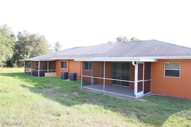4526/4524 28th St SW, Lehigh Acres, FL 33973 - rear view of property featuring a sunroom, central AC, a shingled roof, and a lawn