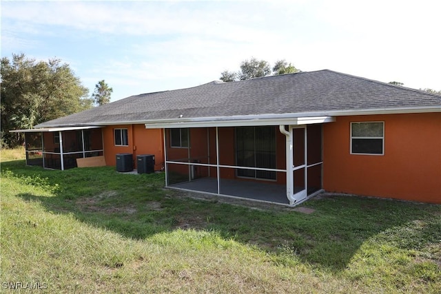 4526/4524 28th St SW, Lehigh Acres, FL 33973 - back of house featuring a sunroom, roof with shingles, a yard, and central AC unit