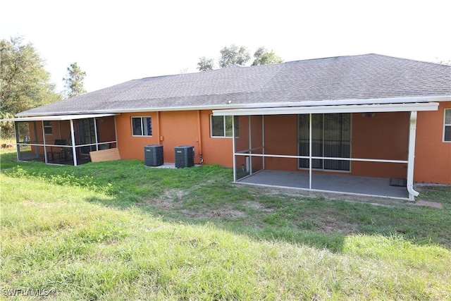 4526/4524 28th St SW, Lehigh Acres, FL 33973 - rear view of property with a sunroom, central AC unit, a shingled roof, and a lawn