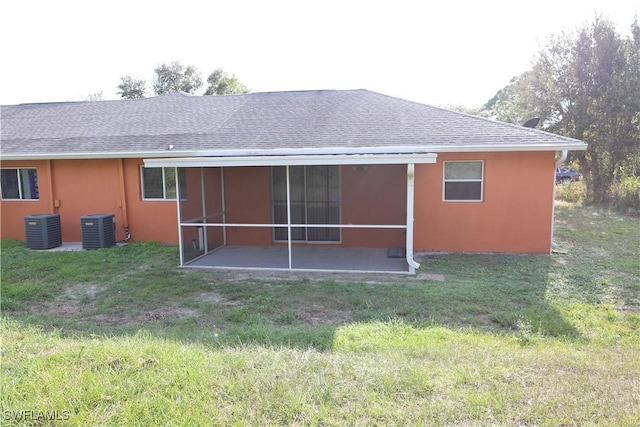4526/4524 28th St SW, Lehigh Acres, FL 33973 - rear view of house featuring a shingled roof, central AC unit, a patio, and a lawn