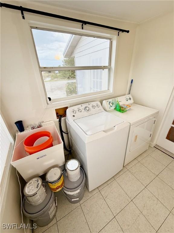 3700 26th St SW, Lehigh Acres, FL 33976 - laundry area featuring washing machine and dryer, light tile patterned floors, and plenty of natural light