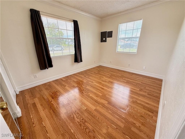3700 26th St SW, Lehigh Acres, FL 33976 - unfurnished room with healthy amount of natural light, wood finished floors, ornamental molding, a textured ceiling, and baseboards