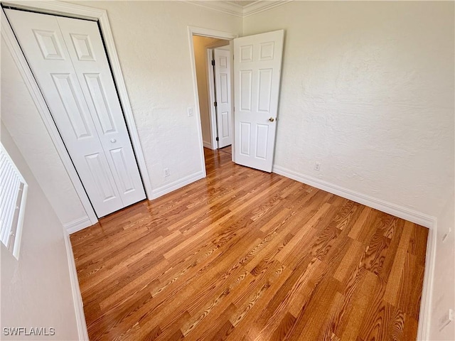 3700 26th St SW, Lehigh Acres, FL 33976 - unfurnished bedroom featuring crown molding, light wood-type flooring, baseboards, and a closet